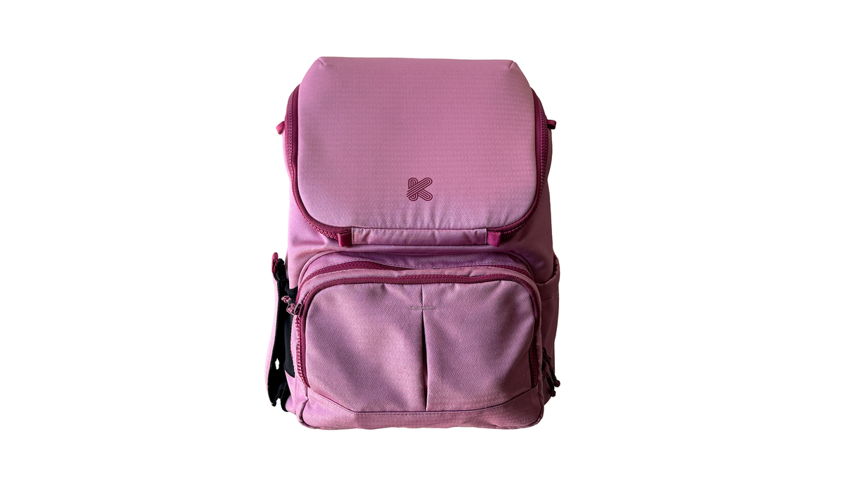 A pink backpack with multiple zippered compartments and a small embroidered logo on the front flap, shown against a plain white background.