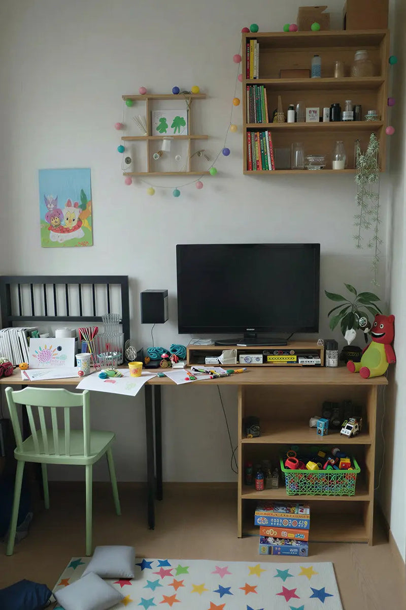 Children's room with a desk, chair, TV, and shelves filled with toys and books.