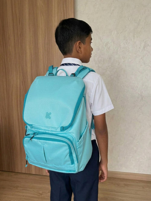 Boy in school uniform with a blue backpack